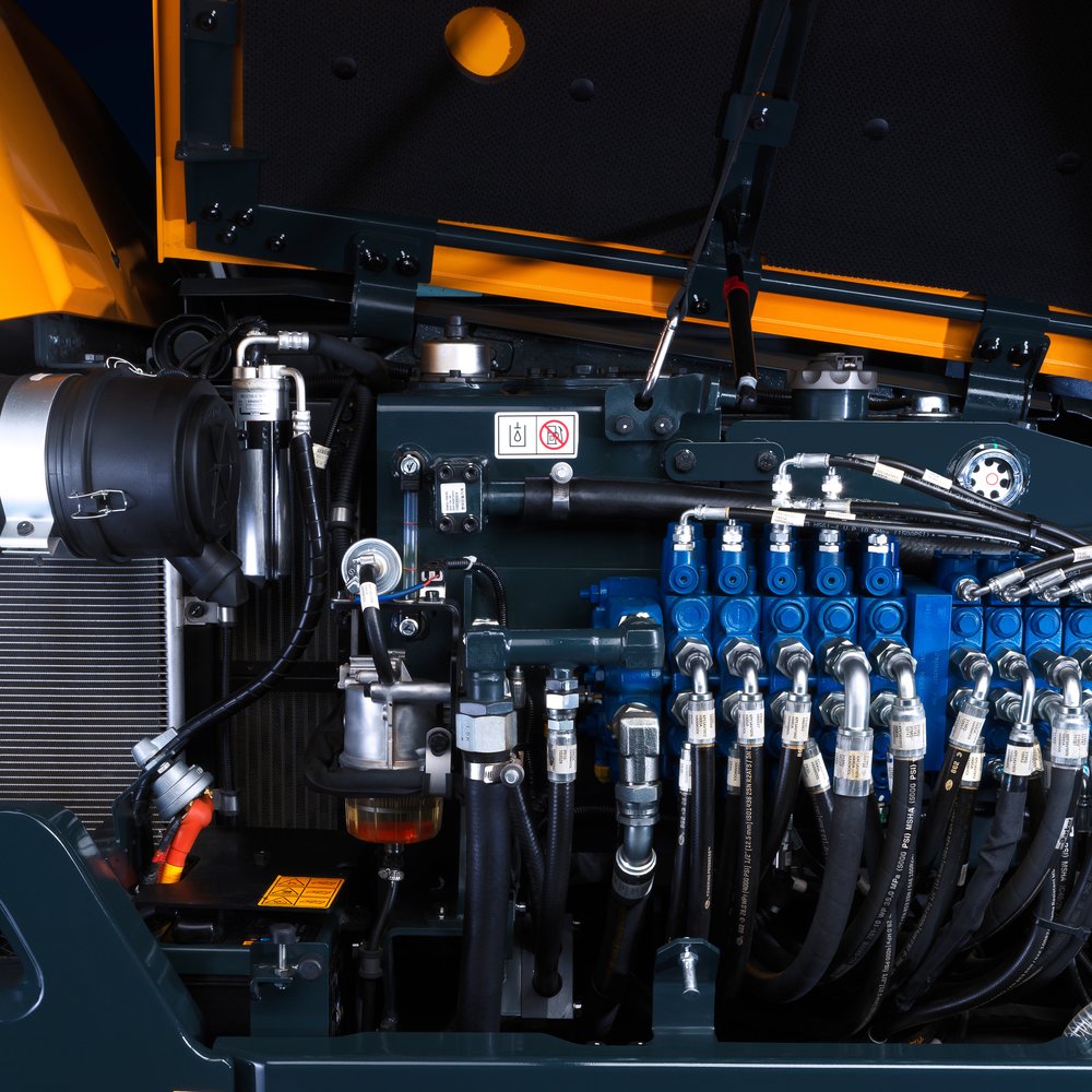 Lähikuva Huyndai-kaivinkoneen moottorista ja hydrauliikan rasvauspisteistä
