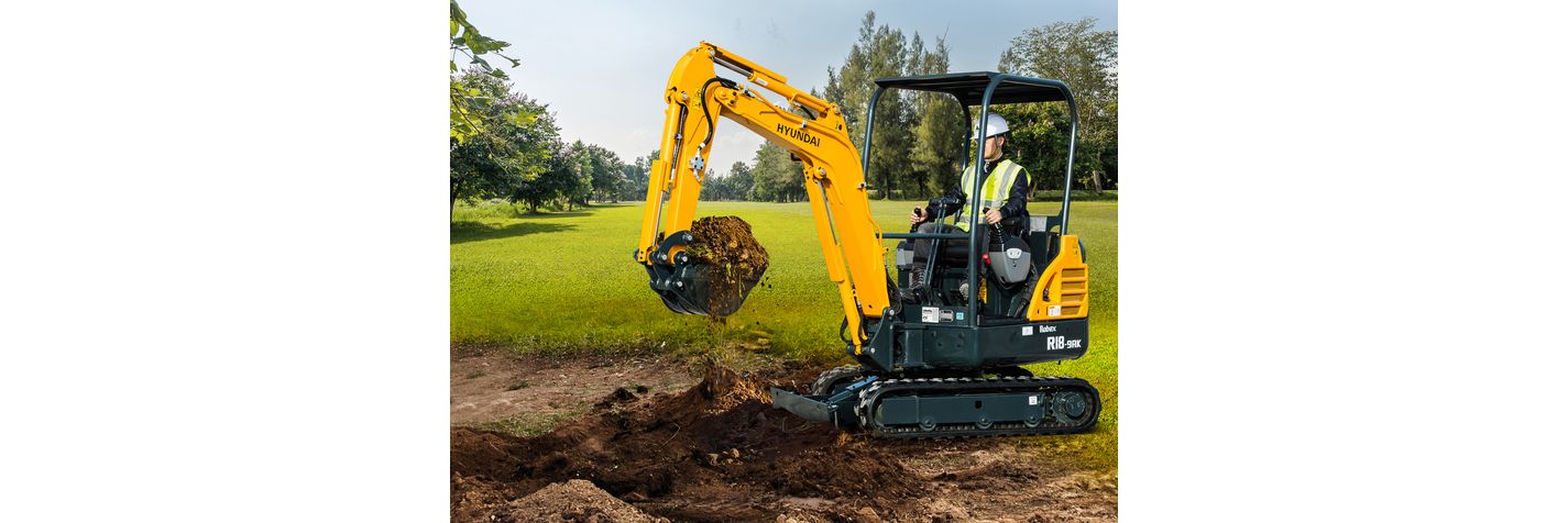 Minikaivinkone Hyundai R 18-9 AK kaivaa multaa puistossa