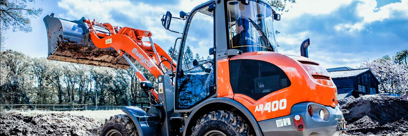 Pyöräkuormaaja Weycor AR400  nostaa hiekkaa kasaan