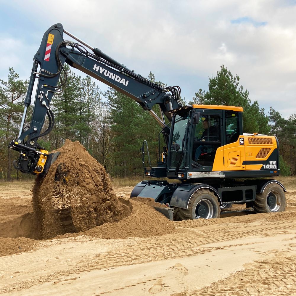 Pyöräkaivinkone Hyundai HW 140 A kaivaa hiekkaa metsämaisemassa