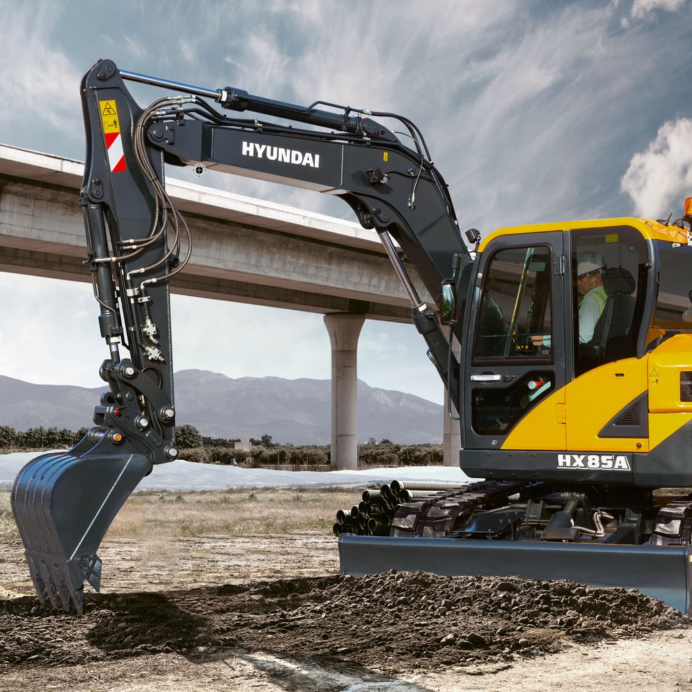 Midikaivinkone Hyundai HX 85 A tasoittaa maata puskulevyä käyttäen